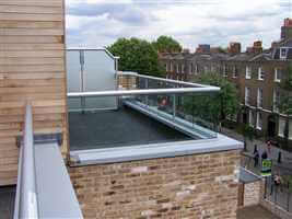 Small balcony with silver handrails and tinted glass privacy screen