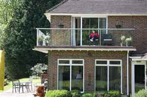 Woman enjoying her balcony with Royal Chrome handrails