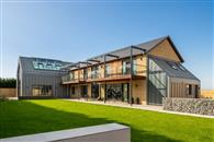 Striking glass balustrades supplied by Balconette add extra external space while opening up extensive countryside views at this unique self-built home.
