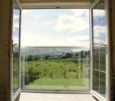 View to the beautiful country side through a Juliet balcony with a white handrail