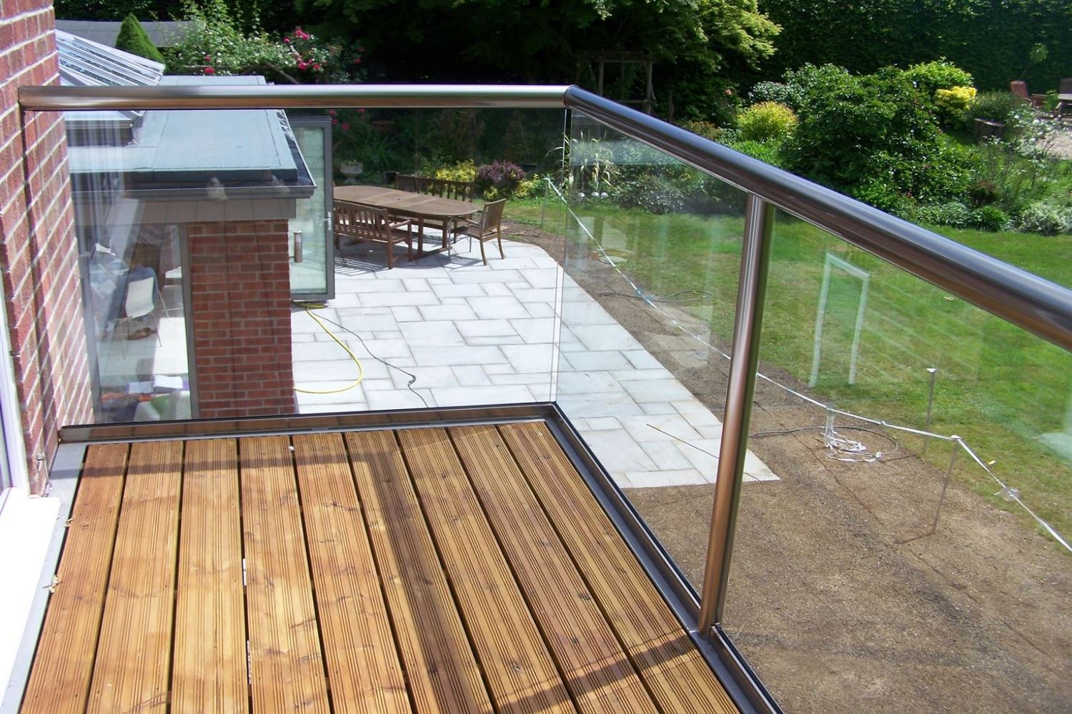Orbit Royal Chrome Glass Balustrade overlooking a garden view with a patio