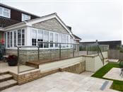 Renovation of a wooden spindle balustrade. Smart new low-maintenance glass balustrade supplied by Balcony Systems has totally transformed the terrace at Somerset property.