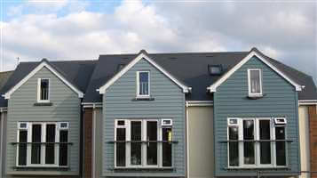 Juliet balconies with Royal Chrome handrails on pretty blue houses