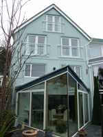 White Juliet balconies on a pretty blue house in the Isle of Man