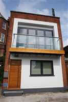 Small brick house with a first level balcony with a Royal Chrome handrail ansd post