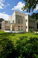 Straight and curved white balconies on a school property surrounded by gardens