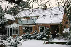 Snowy house with silver handrailed balsutrade