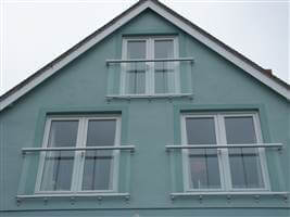 Three White Juliet balconies on a blue house