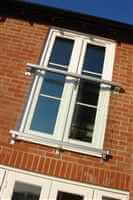 Small Juliet balcony with silver handrail on brick house