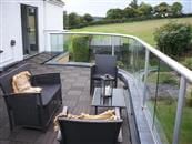 A large kitchen extension topped with a generous roof terrace and curved glass balcony balustrade has opened up spectacular views at their home near Bristol.