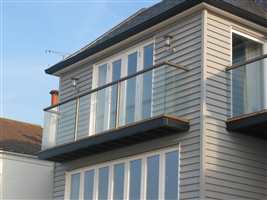 Short clear glass Bronze balcony on the side of a pretty house