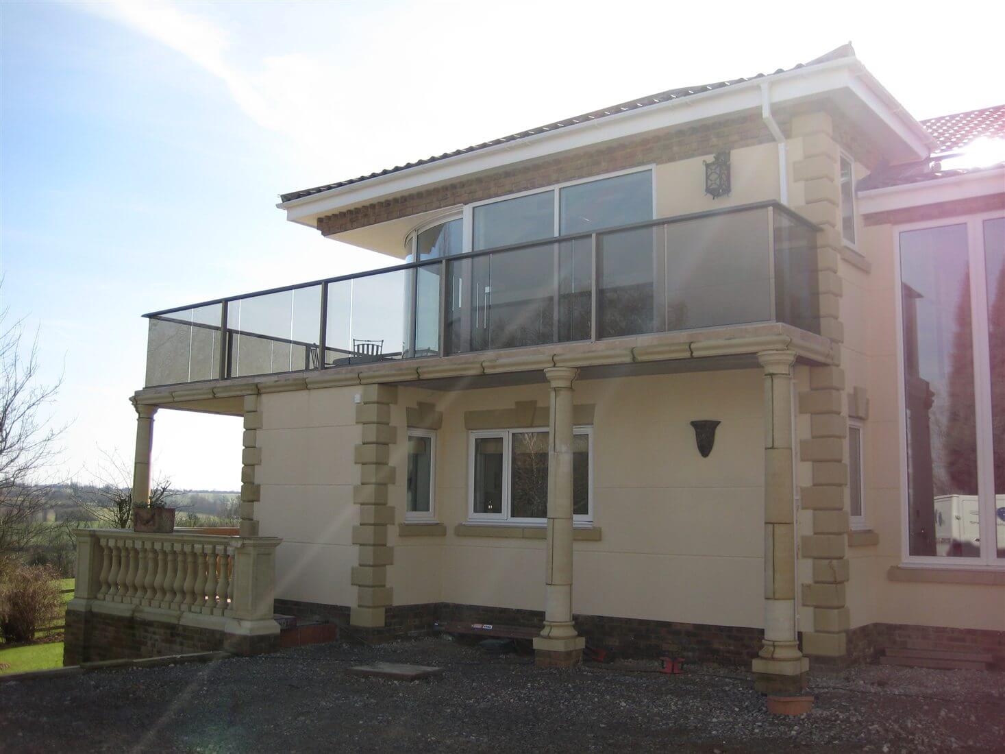 Tinted glass balcony with bronze handrail on beautiful house