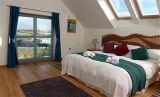 Interior view in a bedroom of Juliet balcony with Silver handrail looking out to countryside