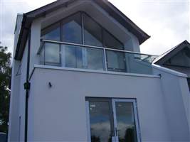 Beautiful white house with stunning glass windows on the top floor leading to Royal Chrome Balcony