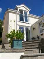 Pretty white house in the sun with small white Juliet balcony