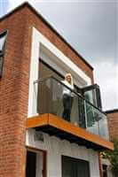 Woman looking down from balcony with clear glass and Royal Chrome handrail and post