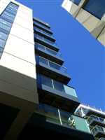 Looking up at balconies with Royal Chrome handrails and posts with blue skies