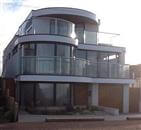 Curved Patio Doors and Royal Chrome Balustrading adding light and space to make a spectacular statement at a detached new build home in Whitstable, Kent.