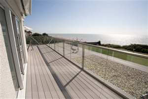side view bronze handrail balustrading geese and the beach in view with blue sky