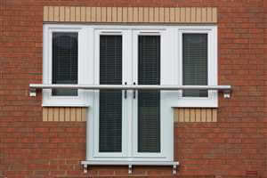 Wide Juliet balcony with Silver handrail on a brick house