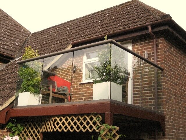 Glass balustrade with bronze handrail and plants