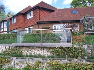 Silver Aerofoil Glass Balustrade installed in a garden