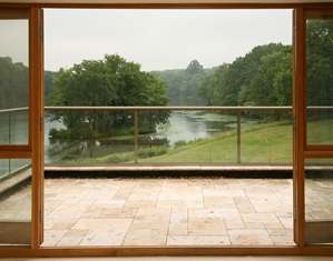 A view through from inside to the pond looking through a clear glass balcony with a self-cleaning glass coating