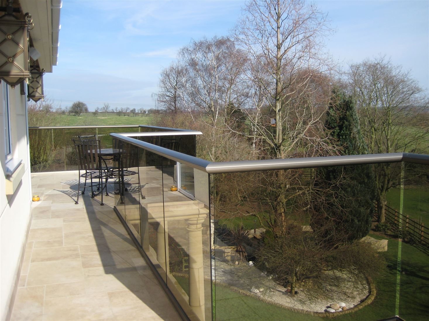 A zigzag glass balustrade with bronze tinted 10mm toughened glass overlooking the countryside