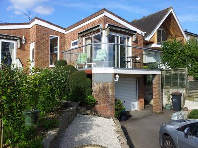 Silver Aerofoil Glass Balustrade installed on a brick house.