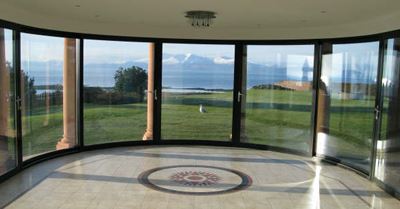 Room with a decorative tile floor and Curved Glass Doors overlooking the coast