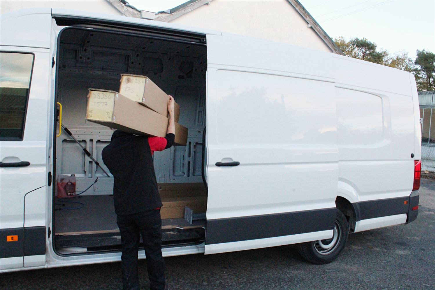 Balconette employee loading long wheelbase vehicle with packaged metalwork