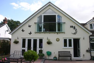 Royal Chrome Aerofoil Juliet Balcony, installed on a cream property with black butterfly decals.