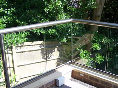 Royal Chrome Orbit Glass Balustrade with a garden view.