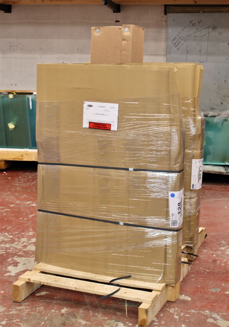 Packaged Juliets and glass strapped to a wooden stillage structure
