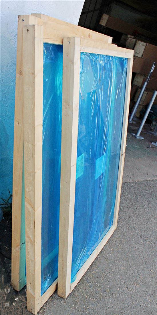 Side view of Balcony glass secured in deep wooden frame ready for delivery 