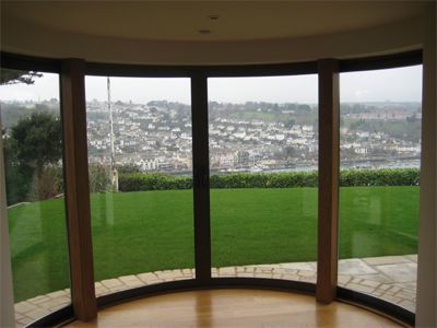 curved glass door looking onto a garden and the town below