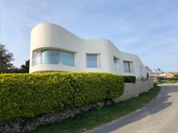 Curved Frameless Glass Balustrade installed on a modern property with cream exterior paint work.