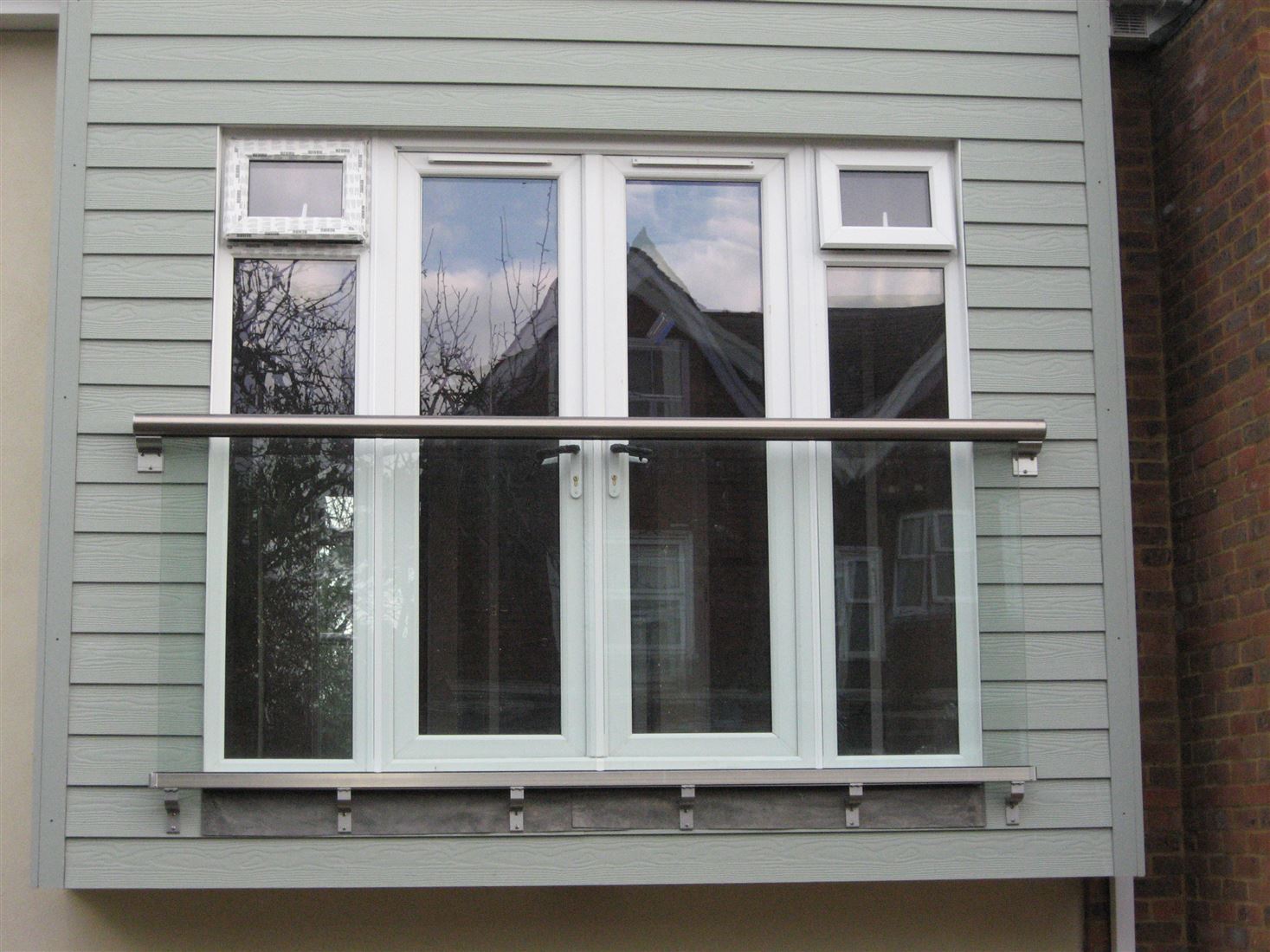 Royal Chrome Orbit Juliet balcony on a blue house