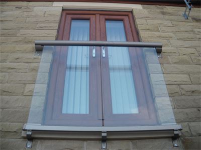 Bronze handrail Juliet balcony on stone wall house