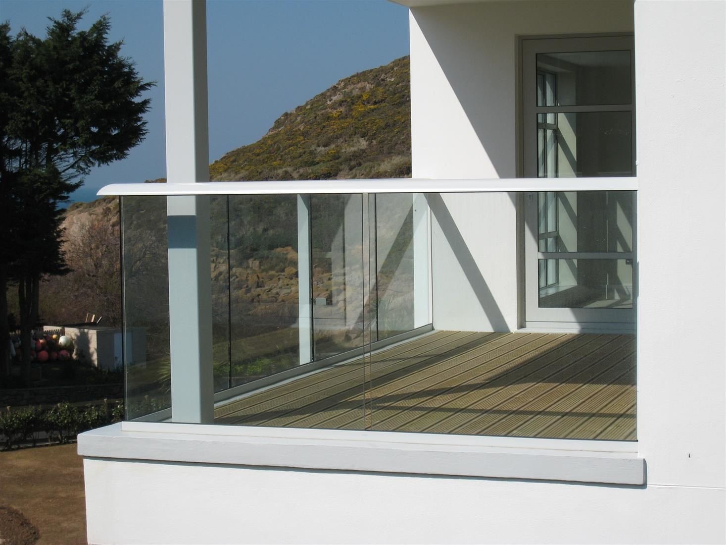 Corner of a White Aerofoil Glass Balustrade overlooking a mountain view