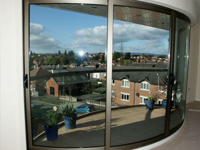 Inside view of the curved glass doors looking out on to a town