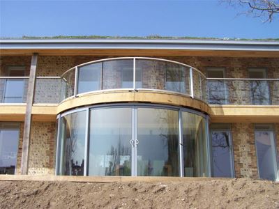 Curved silver aerofoil balustrade with curved sliding doors and blue sky