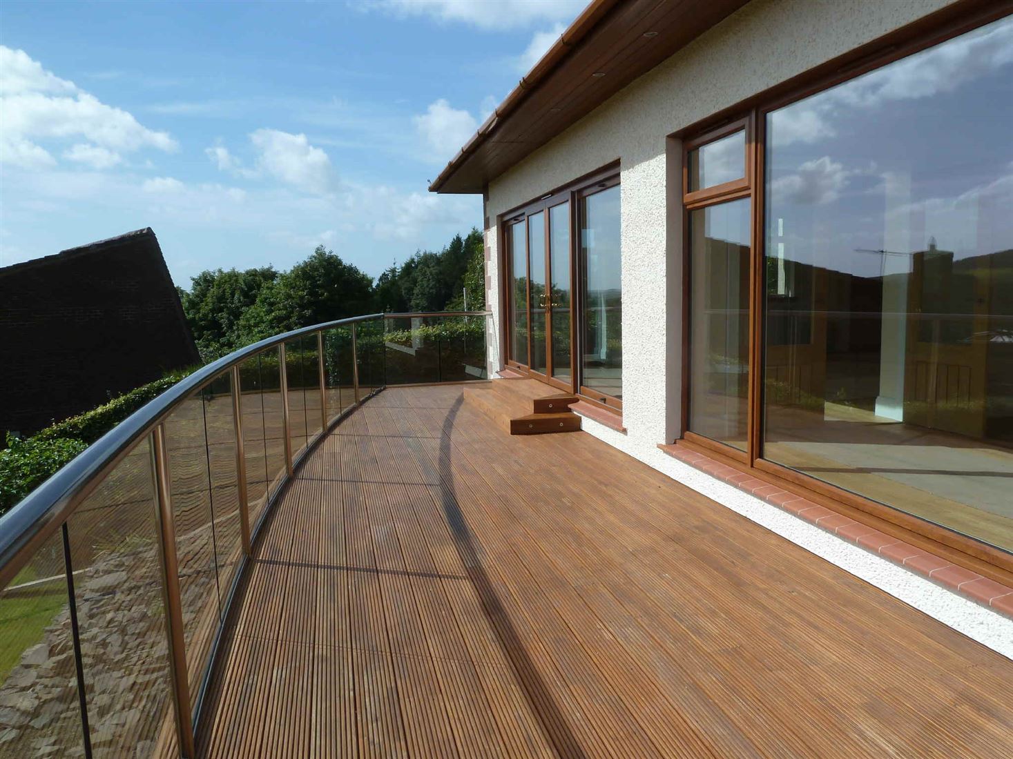 Large curved Royal Chrome Orbit Glass Balustrade overlooking the countryside