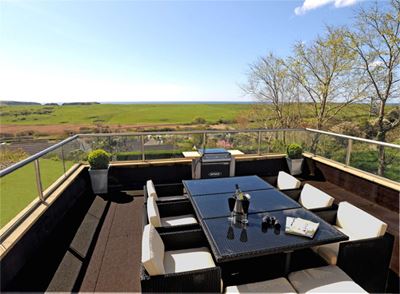 table and chairs set up on a Royal Chrome balustrade balcony with stunning countryside views