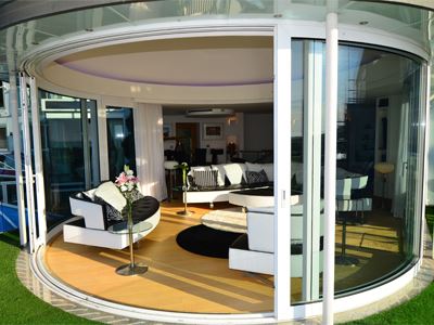 Open curved glass door going into modern seating area