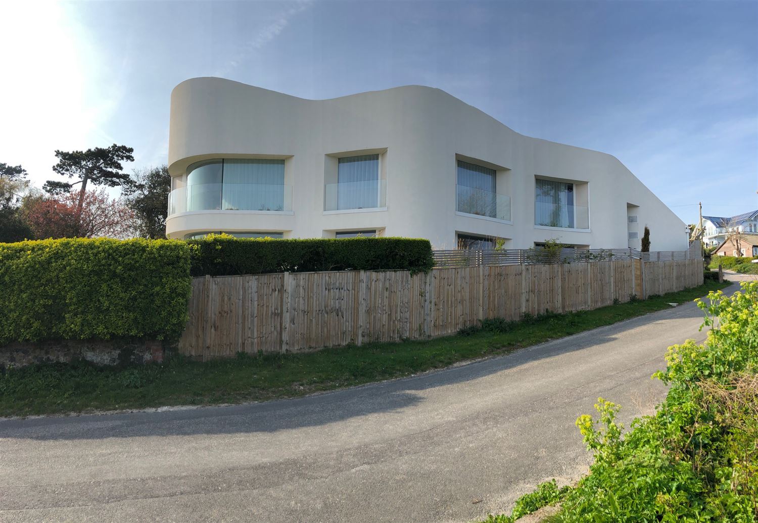 Curved Frameless Glass Balustrade installed on a modern property with cream exterior paint work.