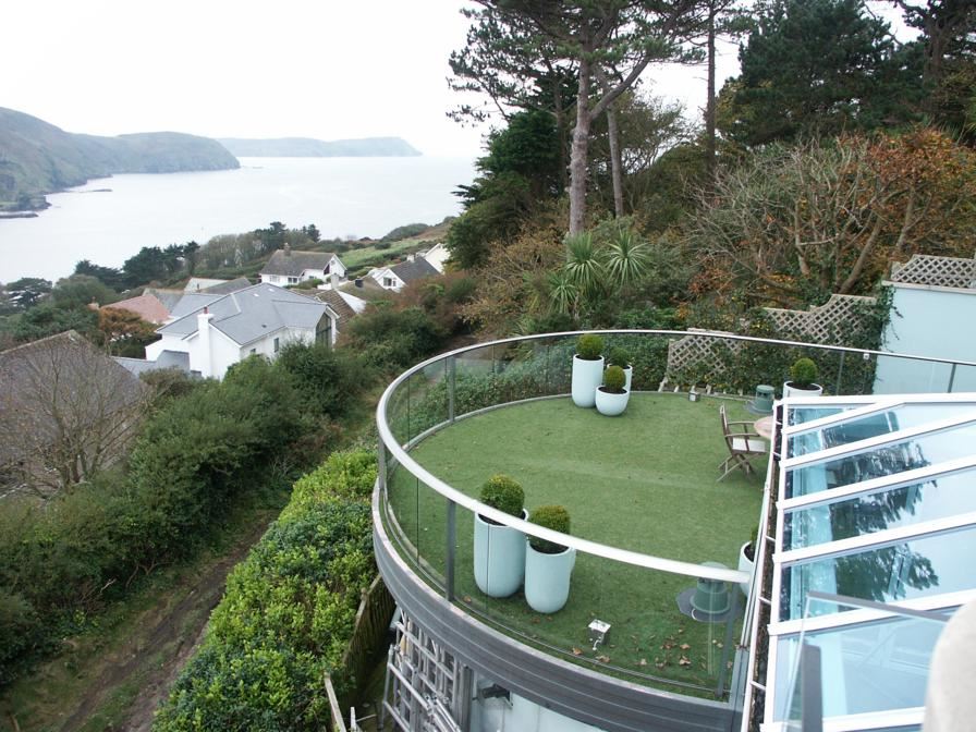 View down the hill to the water from a Curved Royal Chrome Aerofoil Glass Balustrade at this Isle of Man property